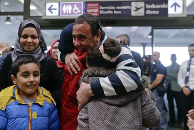 Syrian refugees hug each other upon their arrival at Rome's Fiumicino international airport, Monday, Oct. 24, 2016. Seventy-five refugees landed at Rome's Leonardo Da Vinci airport thanks to the "humanitarian corridor" project launched by the Rome-based Catholic Sant'Egidio Community and the Federation of Protestant Churches in Italy. (AP Photo/Gregorio Borgia)