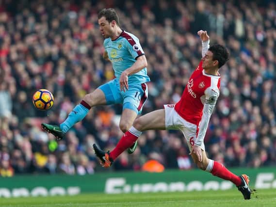 Ashley Barnes challenges for the ball with Laurent Koscielny