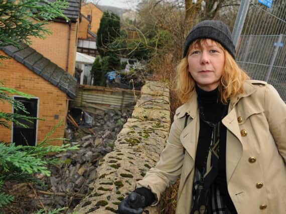 Resident Mrs Ceri Carmichael surveys the damage after the wall collapse in Printers Fold, Burnley.