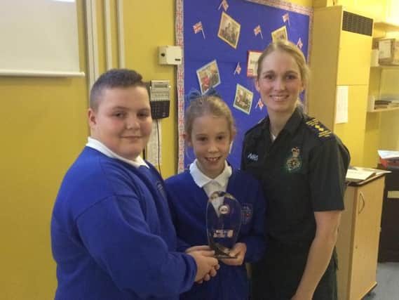 Padiham Primary School pupils Leighton and Emily receive the Cardiac Smart Award from Cheryl Pickstock of the North West Ambulance service.
