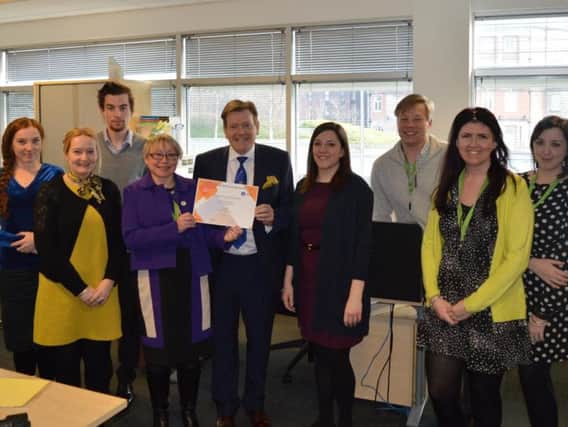 Kevin Poynton of the Lancashire Freemasons (centre) presents certificate to Cath Stanley, Chief Exec of Huntington's Association (fourth from left) and staff.
