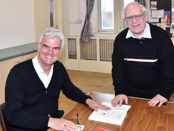 Peter Slater signs a copy of his book Dont You Know Who I Am for Pendleside Probus Club President Keith Richardson. (s)