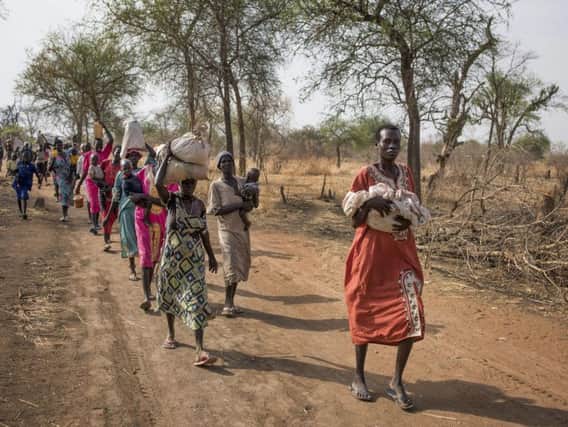 People walk for hours to reach a food distribution site in Malualkuel, in the Northern Bahr el Ghazal region of South Sudan