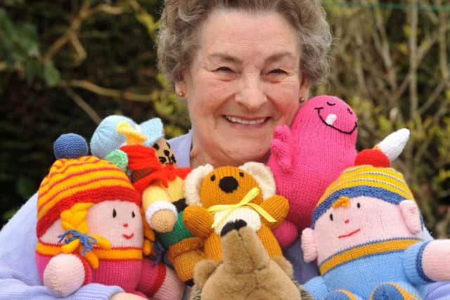 Audrey Bates with a selection of the knitted toys she makes to sell to raise money for animal charities.