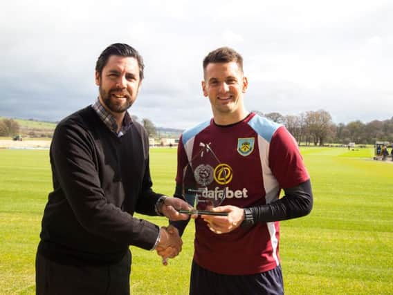 Neil Hart, CEO of Burnley FC in the Community, presents the award to Tom Heaton (right).