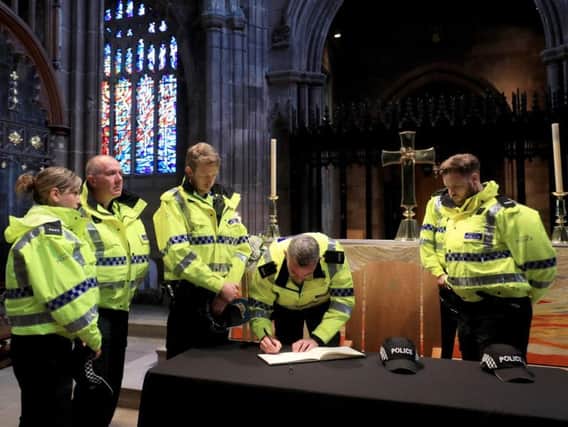 Police officers sign the book of condolence at Manchester Cathedral