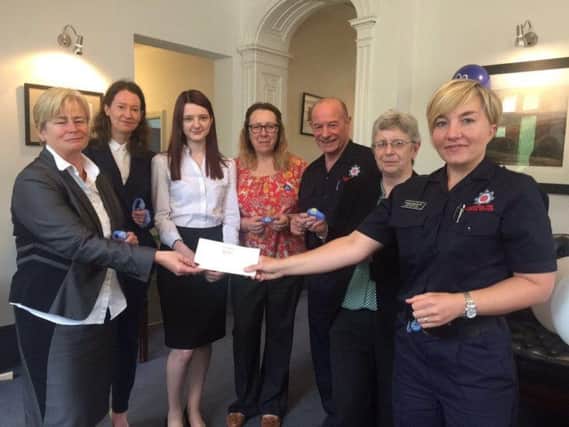 Staff at Southerns present a cheque to Angela Hammonds, the Community Fire Safety Team Leader for thePennine area, to help fund the Dementia Buddies scheme.