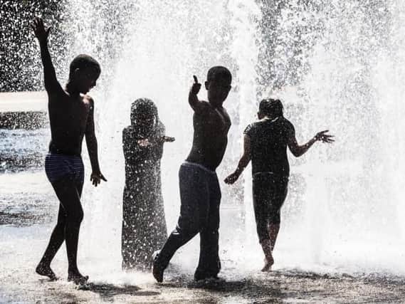 Children play in a water fountain as Britain is set to bask in its hottest day of the year this weekend, with the fine weather continuing into next week.