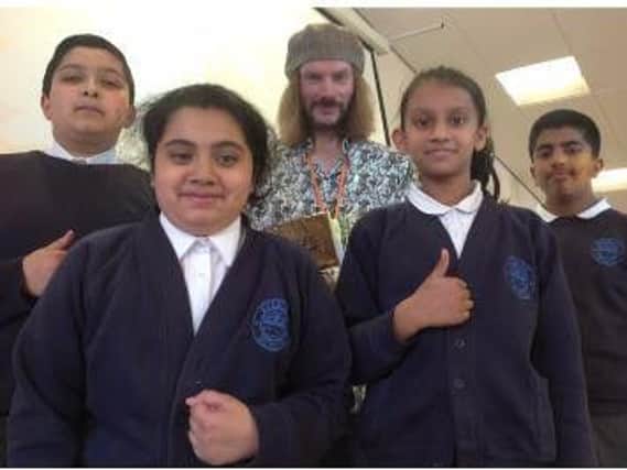 Poet Ash Dickenson with year six pupils Shoaib Ali, Amna Javed, Laibah Ahmed and Abubaker Naweb.