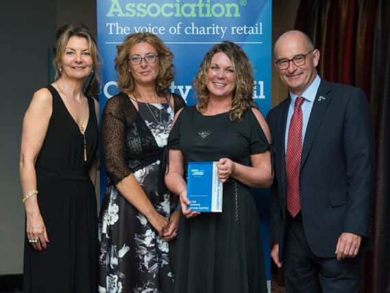 The Pendleside Hospice team claiming their Innovation in Charity Retail award with Jo Caulfield (far left).