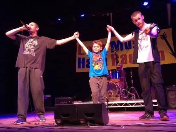Matthew Bennett on stage at the Love Music Hate Racism concert with his sons Callum and Logan.