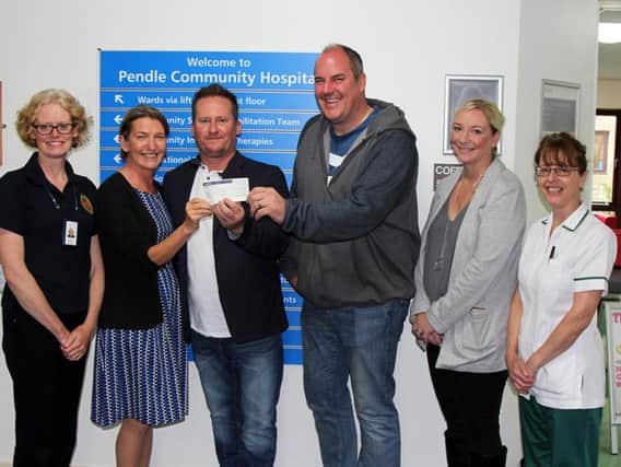 Paul, Clare and Simon present the cheque to Sue Targett watched by staff from the stroke therapy unit.