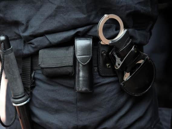 A baton and handcuffs carried by a police officer