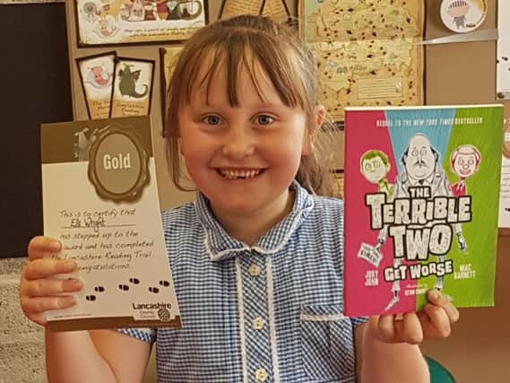 Elle Wright is all smiles after winning a gold award for reading and reviewing 50 books at the age of seven.