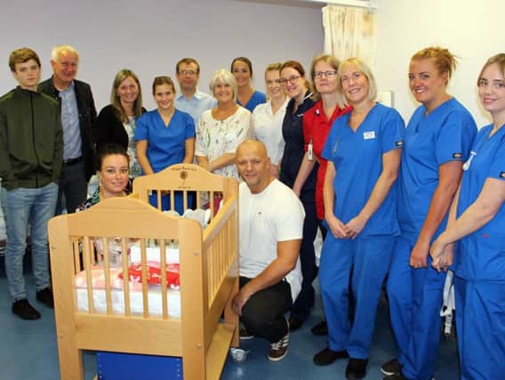 Mark and Sarah and their son Oliver hand over their second cold cot to staff at the
East Lancashire Hospitals NHS Trust.