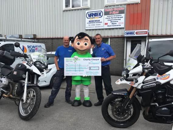 David (right) and John hand over a cheque for 6,000, the money their epic 8,000 mile bike trip round Europe raised for Derian House children's hospice.