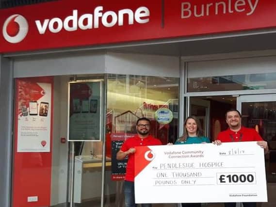Staff at Burnley Vodafone with a 1000 cheque for Pendleside Hospice. (s)