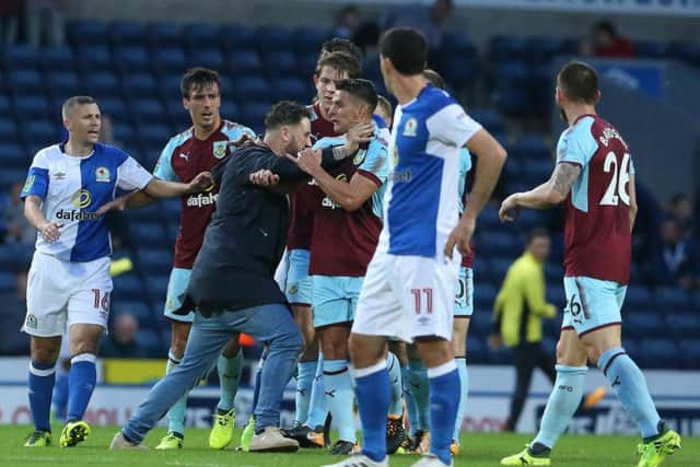 The pitch invader grabbed Clarets midfielder Ashley Westwood by the neck