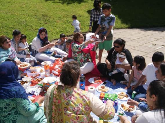 Participants of Creative Families in the Community enjoying a picnic together. (s)