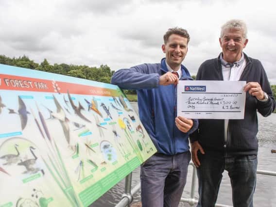 Parks development officer, Sean Kerr, receives the cheque from Richard Burrow, chair of Burnley and Pendle District Angling Association.