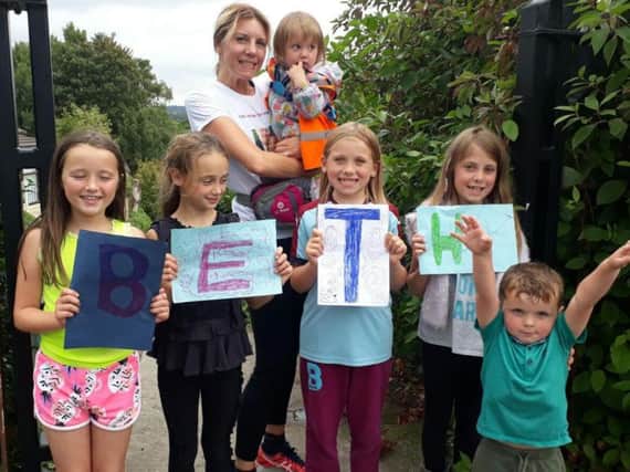 Beth Schinkel celebrates completing her charity run with her daughters Maggie  (who she is holding) and Annie (second from right) with other youngsters from their childminding group who are (left to right) Maisy McVay (eight) Olivia Metcalf (nine) Aaliyah Lawrence (nine) and three-year-old Archie Sadler.