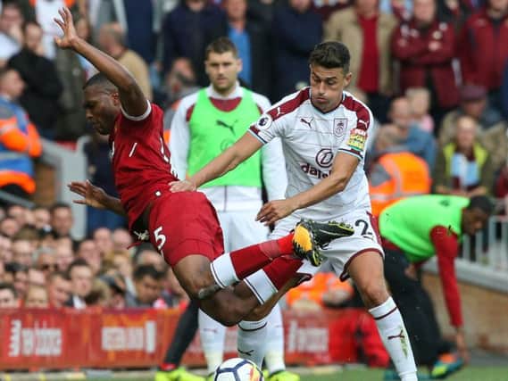 Matt Lowton fights for possession with Liverpool striker Daniel Sturridge