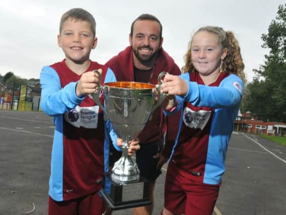 Year six pupils Archie Hamer and Isabel Moffitt with Mr Peyton and the Burnley Schools Sports Partnership Trophy.