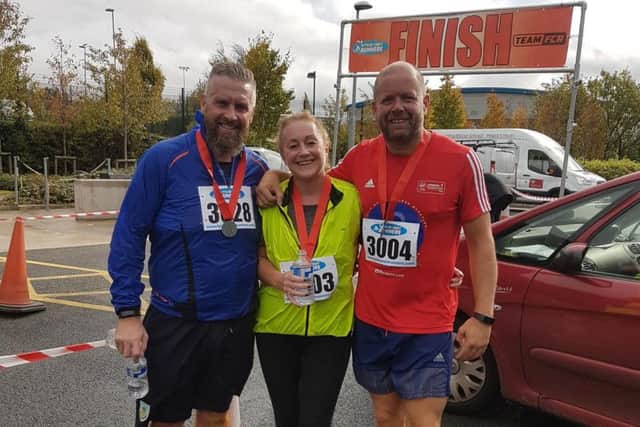 Pictured at the finishing line of the Burnley Fire 10k race are organiser Dave Clegg (right) with Jason Whittaker and Kim Coffey, who each clocked personal best finishing times this year.