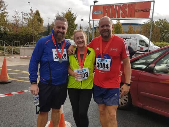 Pictured at the finishing line of the Burnley Fire 10k race are organiser Dave Clegg (right) with Jason Whittaker and Kim Coffey, who each clocked personal best finishing times this year.