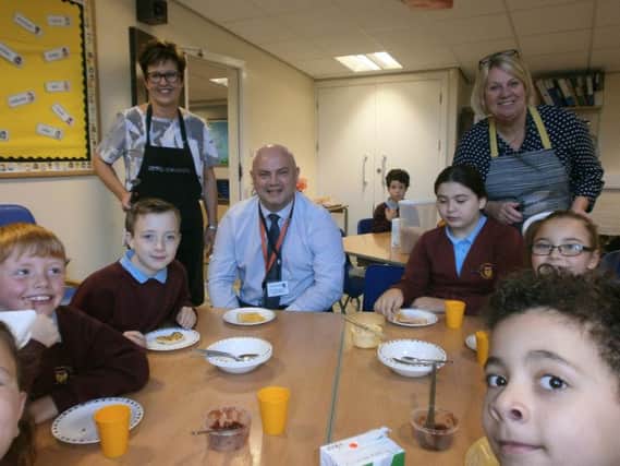 Special guest Gary Dugdale, of Warburton's bakery, is served by Helen Lord and Allison Cheung at the Holy Trinity Primary School breakfast club.
