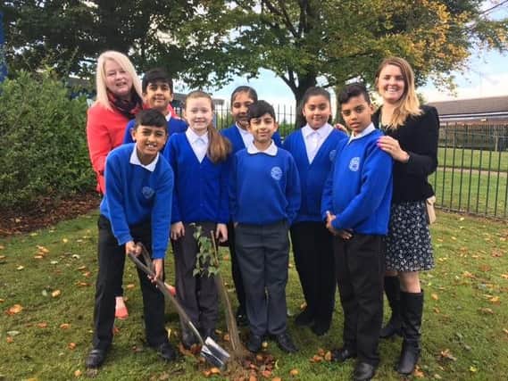Reedley Primary School pupils planting a sapling.