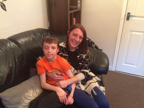 Tyler Norris-Sayers, who has undergone the first of a series of operations after he was hit in the face with a firework one year ago, with his mum, Nicola.