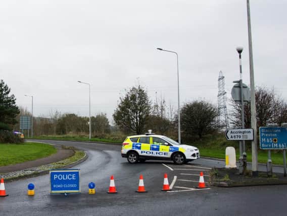 Police cordon off the road while they investigate the accident that claimed the life of a 21-year-old woman today.
