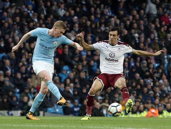 Manchester City's Kevin De Bruyne passes despite the attentions of Burnley's Jack Cork