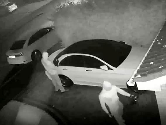 The footage shows two men pull up outside the victim's house, holding a relay box
