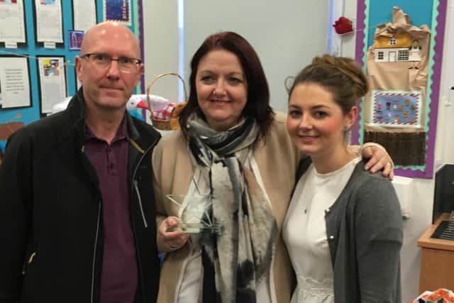 Carole is pictured with her award and her husband Paul and daughter Charlotte.