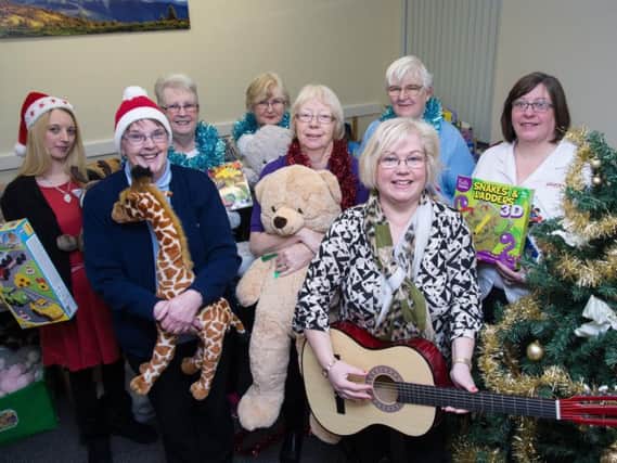 Capt Maisie Veacock (far right) and Burnley Express reporter Sue Plunkett (front) with staff and volunteers with all the toys at the Salvation Army citadel in Burnley.