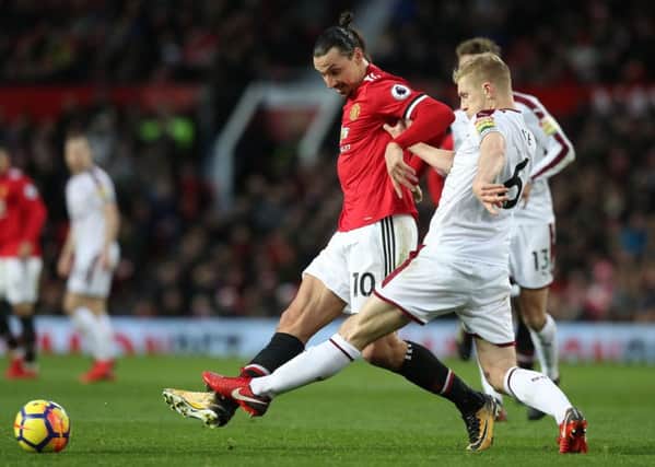 Manchester United's Zlatan Ibrahimovic (left) and Burnley's Ben Mee in action during the Premier League match at Old Trafford, Manchester. PRESS ASSOCIATION Photo. Picture date: Tuesday December 26, 2017. See PA story SOCCER Man Utd. Photo credit should read: Martin Rickett/PA Wire. RESTRICTIONS: EDITORIAL USE ONLY No use with unauthorised audio, video, data, fixture lists, club/league logos or "live" services. Online in-match use limited to 75 images, no video emulation. No use in betting, games or single club/league/player publications.