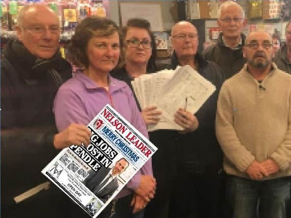 Staff and customers at Park News, Barrowford, with the petition against the application by Booths supermarket.