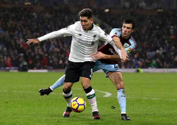 Liverpool's Roberto Firmino (left) and Burnley's Jack Cork (right) battle for the ball during the Premier League match at Turf Moor, Burnley. PRESS ASSOCIATION Photo. Picture date: Monday January 1, 2018. See PA story SOCCER Burnley. Photo credit should read: Martin Rickett/PA Wire. RESTRICTIONS: EDITORIAL USE ONLY No use with unauthorised audio, video, data, fixture lists, club/league logos or "live" services. Online in-match use limited to 75 images, no video emulation. No use in betting, games or single club/league/player publications.