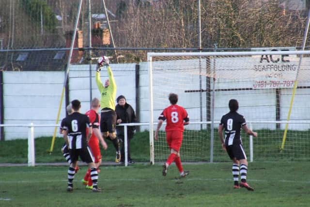 Goalkeeper Chris Thompson eases the pressure by claiming the ball against Atherton Collieries