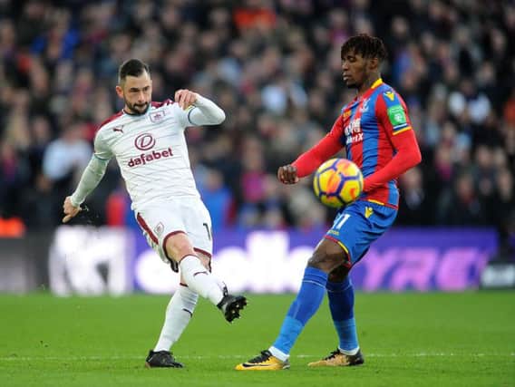 Steven Defour plays the ball past Wilfred Zaha