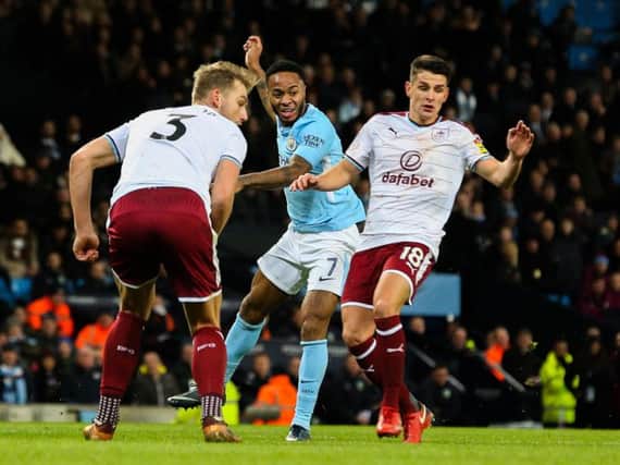 Manchester City's Raheem Sterling takes on Burnley's Charlie Taylor and Ashley Westwood.