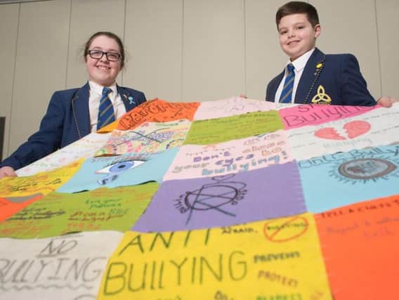 Blessed Trinity RC College's anti bullying ambassador, Yvette Lecheminant, with year seven student James Firminger with the anti- bullying quilt.