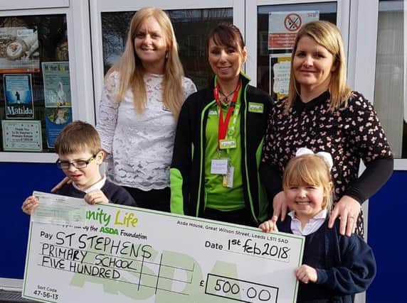 Asda representative Annette McGowan-Doe  presents the cheque to St Stephen's Primary School with headteacher Mrs Cornwell, teacher Mrs Hargreaves and pupils Ruben Law and Isobelle Barlow.
