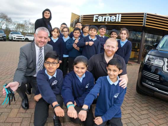 Ian Digger (far left), Head of Business at Farnell Nelson Land Rover with Sports Coach Peter Connor (far right) and Bradley Primary School Children and their teacher Mrs Ishfaq.