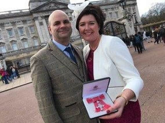 Constable Claire Batt and her husband Mitch are pictured outside Buckingham Palace after she was presented with her MBE.