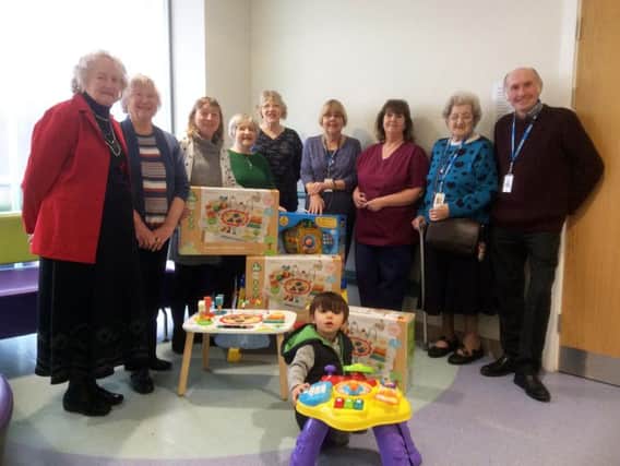 The toys donated by the League of Voluntary Workers are already a hit with this young patient at Burnley General Hospital.