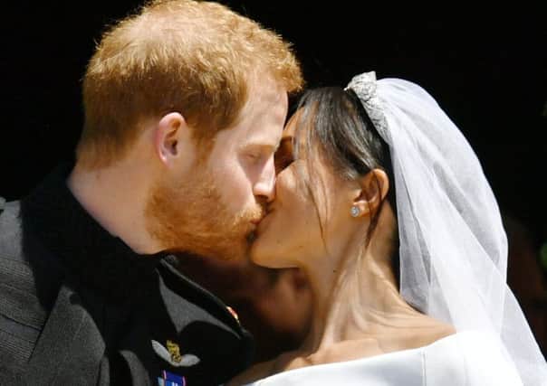Prince Harry and Meghan Markle kiss on the steps of St George's Chapel in Windsor Castle after their wedding. Ben Birchall/PA Wire