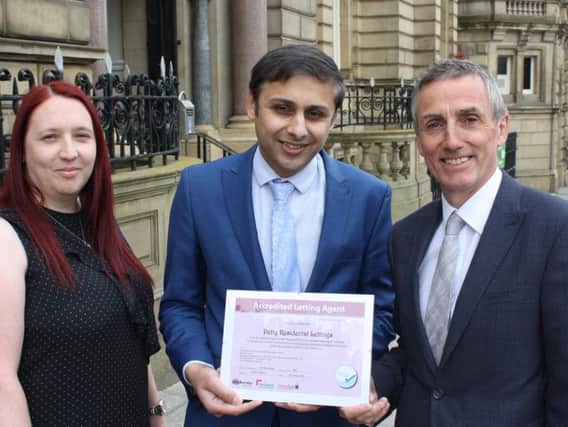Burnley Council chief operating officer Lukman Patel (centre) presents Joanne Cudworth, assistant lettings manager and Simon Westwell, director, of Petty estate agents with its certificate.